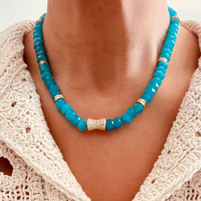 turquoise Amazonite beaded necklace with a textured gold center accent, paired with a cream-colored crochet knit top.